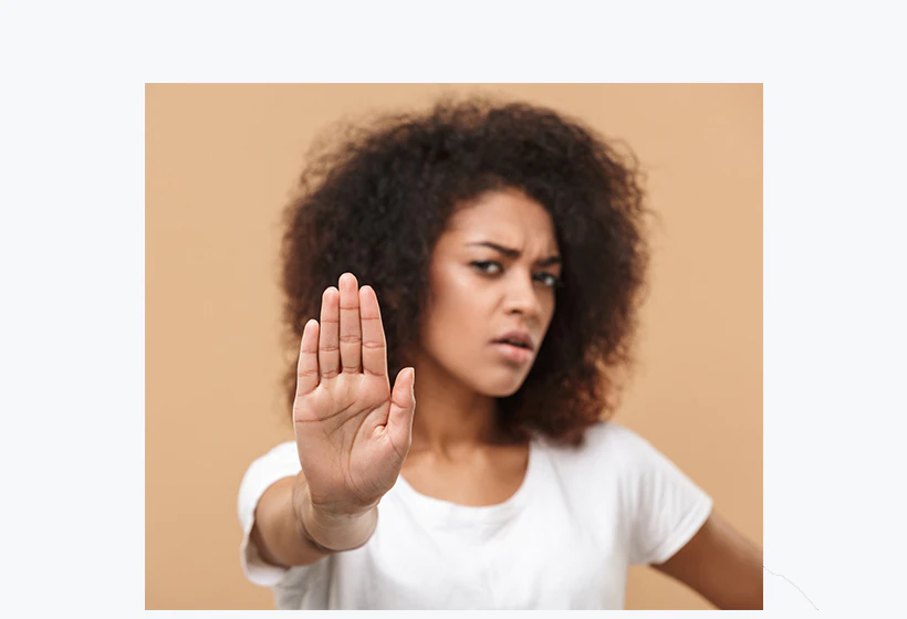 une femme de face avec une main en avant signifiant "stop"